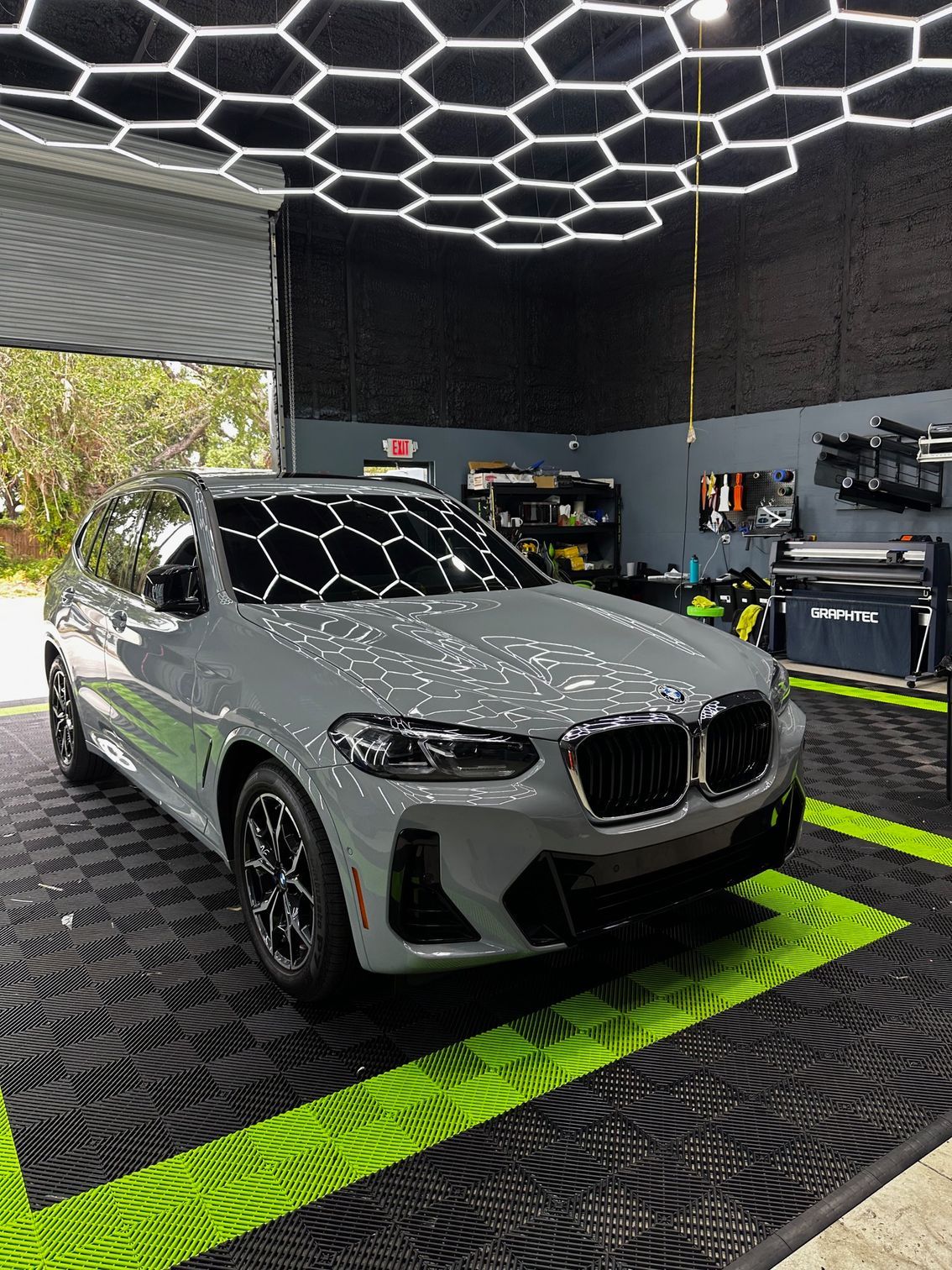A gray bmw x4 is parked in a garage.