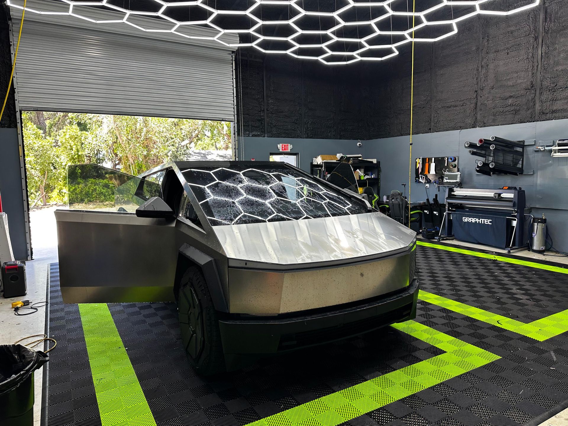 A tesla model s is parked in a garage with its doors open.