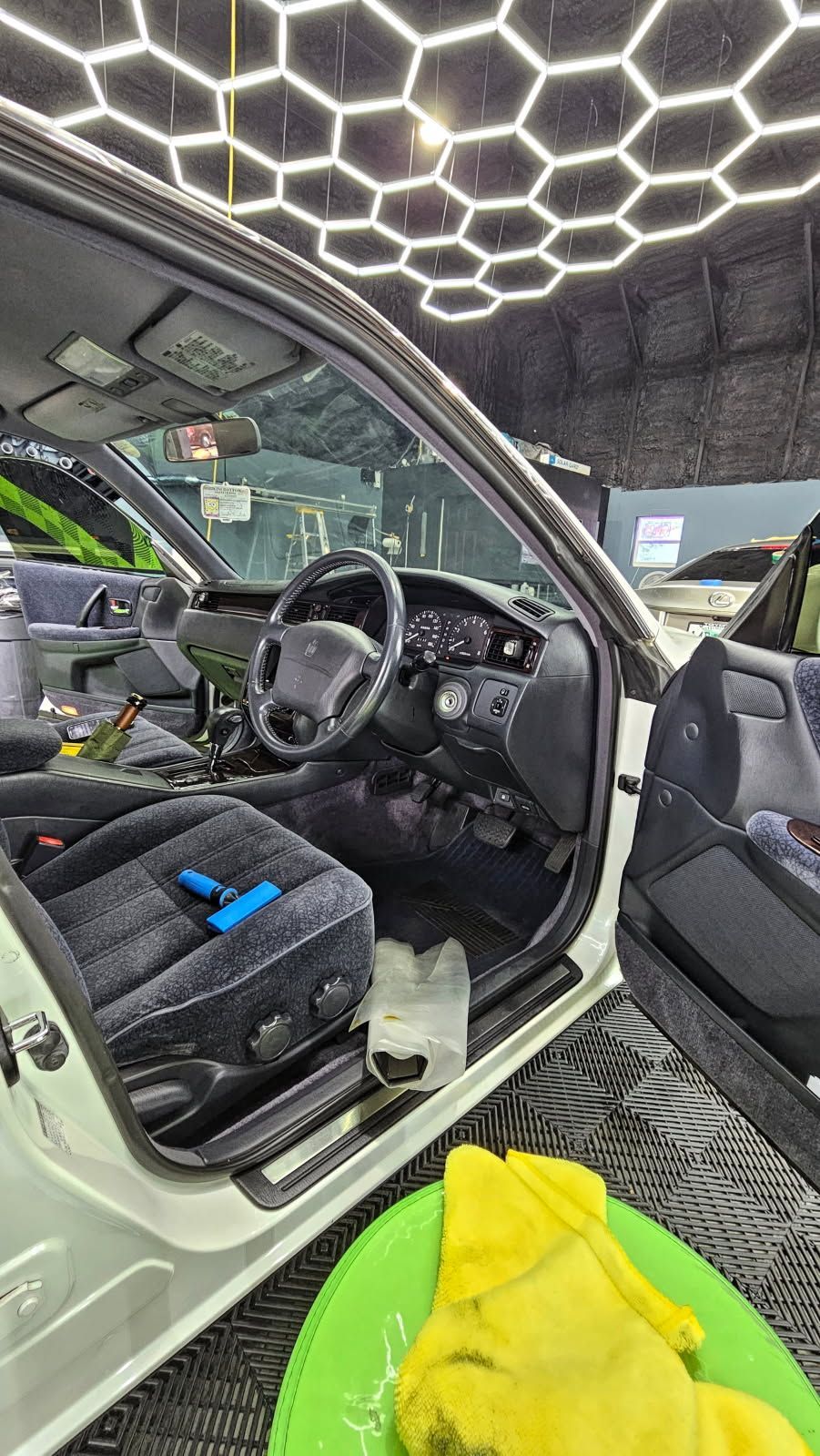 The interior of a white car is being cleaned in a car wash.