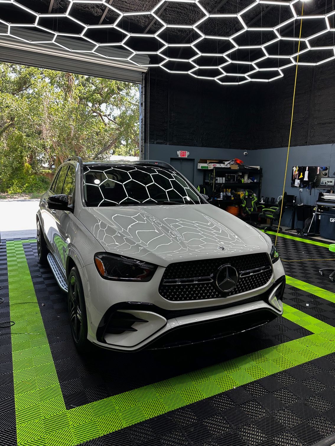 A white mercedes benz gle 450 is parked in a garage.