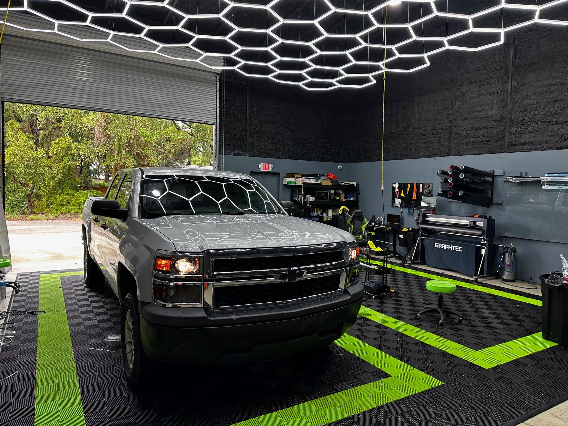 A truck is parked in a garage with the door open.