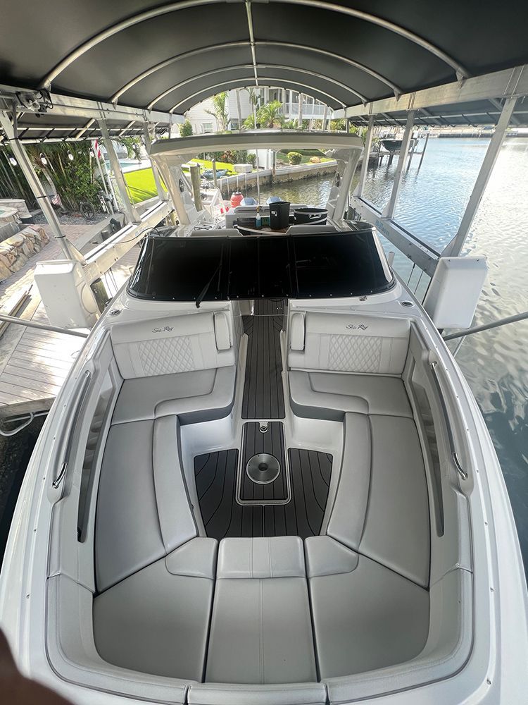 A white boat is docked at a dock in the water.