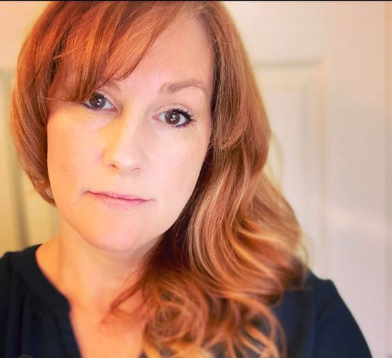 A woman is getting her hair cut by a hairdresser in a salon.