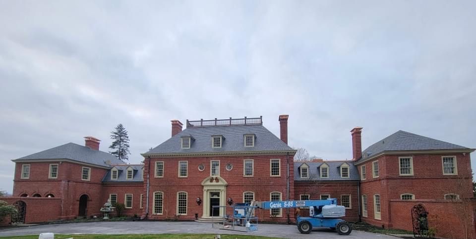 A large brick building with a blue crane in front of it.