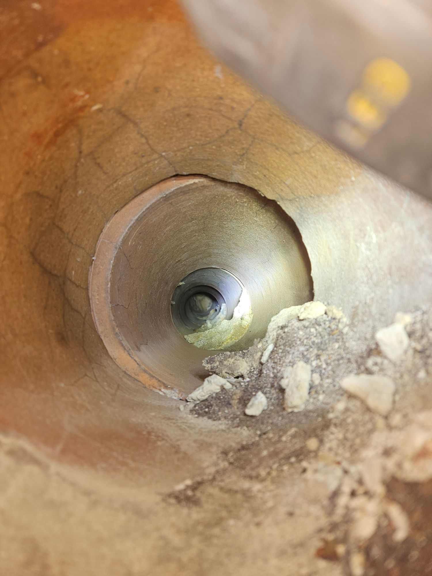 A close up of a hole in a pipe with a light shining through it.
