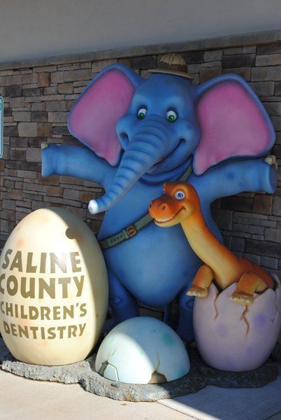 Blue elephant and dinosaur sculptures outside Saline County Children's Dentistry.