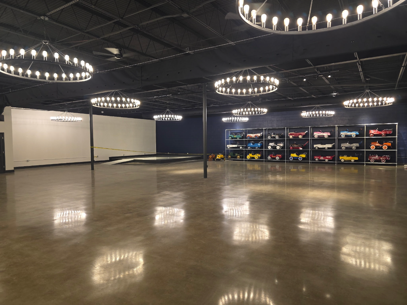 Spacious showroom with polished floor, ring lights overhead, and display cases along the right wall.