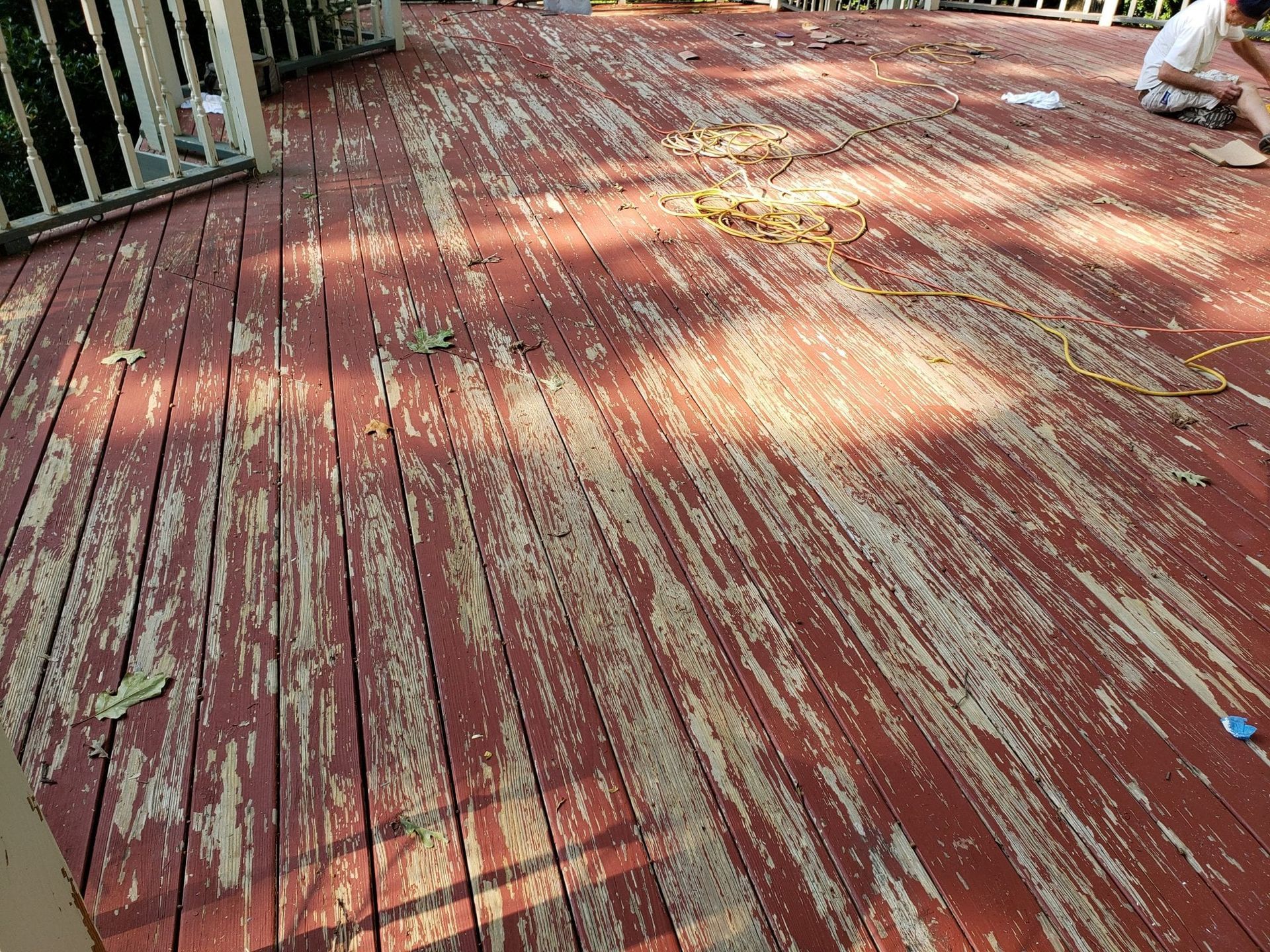 Deck with peeling red paint. Sunlight.