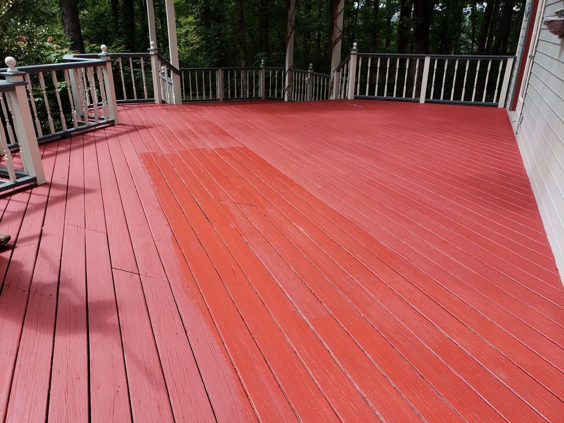 Red painted wooden deck with a lighter, faded rectangular section.
