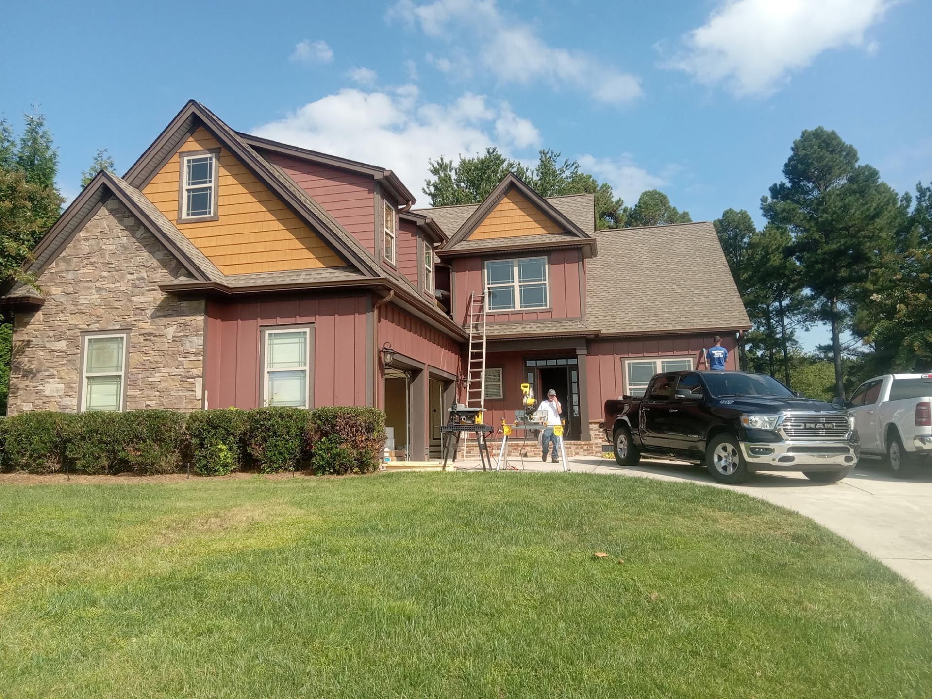 A house exterior with workers before painting services