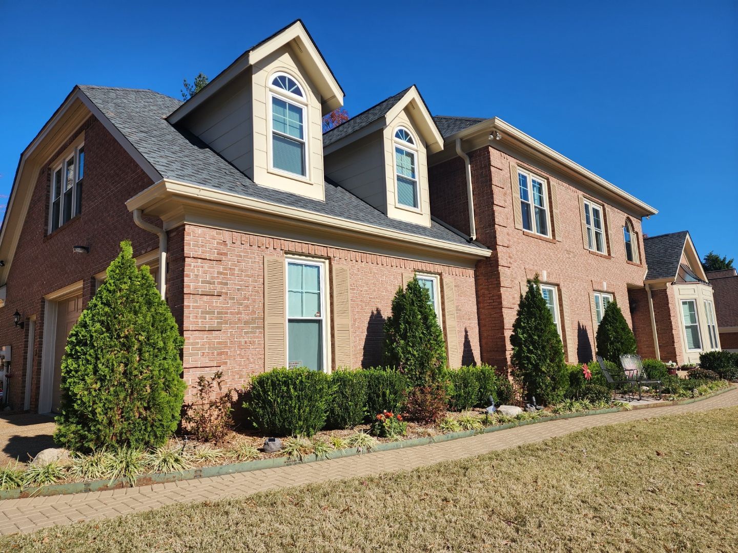 A large brick house with a gray roof and many windows