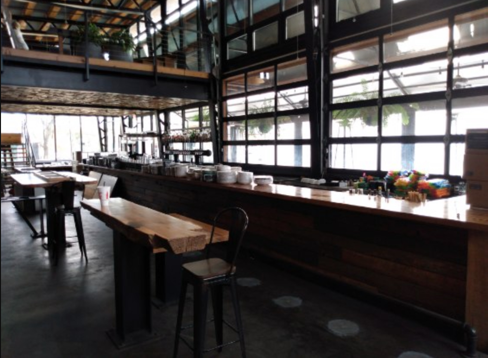 Interior of a restaurant with a wooden bar and tables