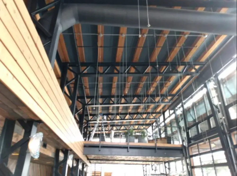 A large building with a wooden ceiling and a metal structure