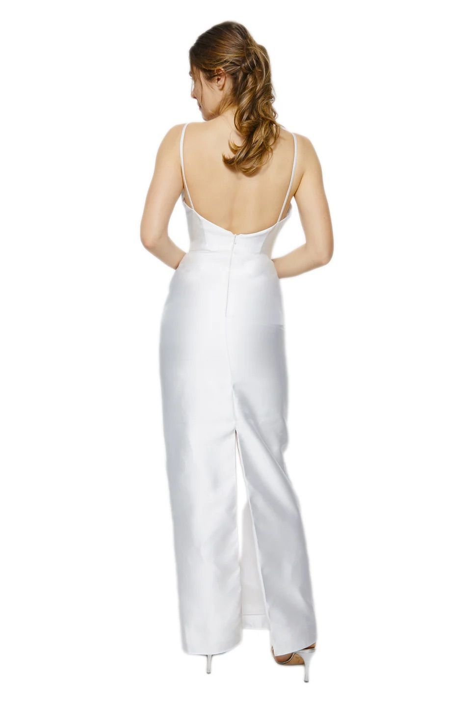 A woman is shown from the back, wearing a white dress and heels.