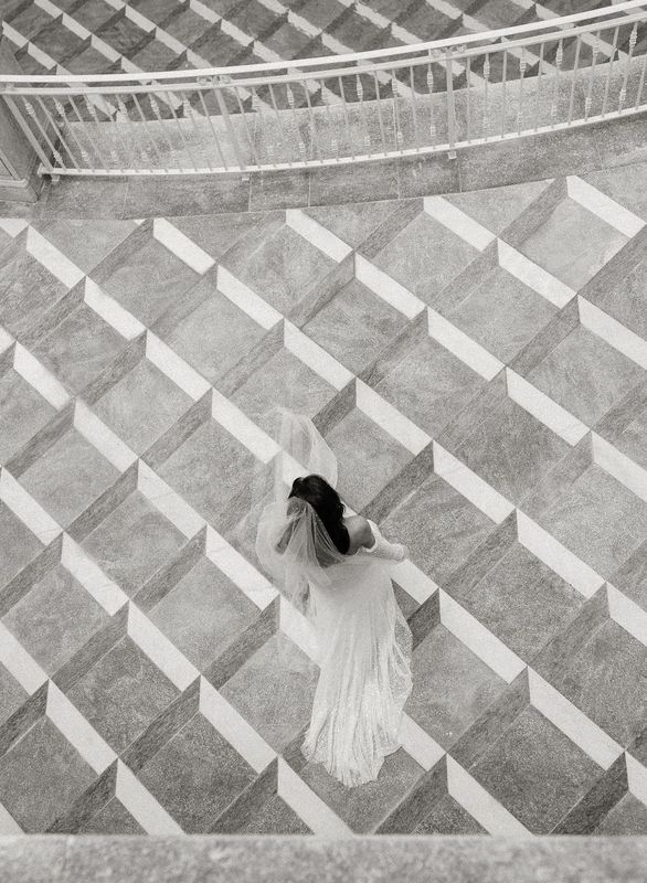 A woman in a white dress is walking down a set of stairs.