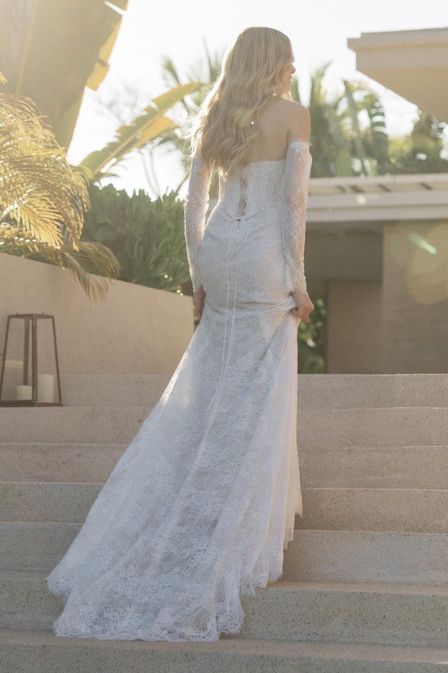 A woman in a wedding dress is standing on a set of stairs.