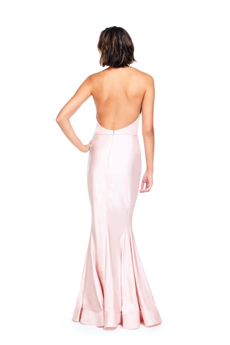 The back of a woman wearing a pink dress with a halter neckline.