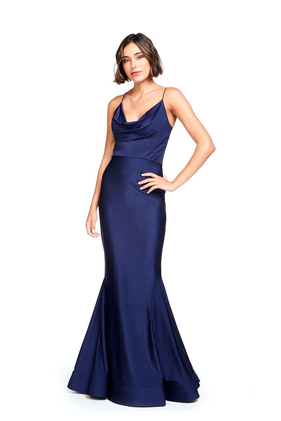 A woman in a long blue dress is standing on a white background.