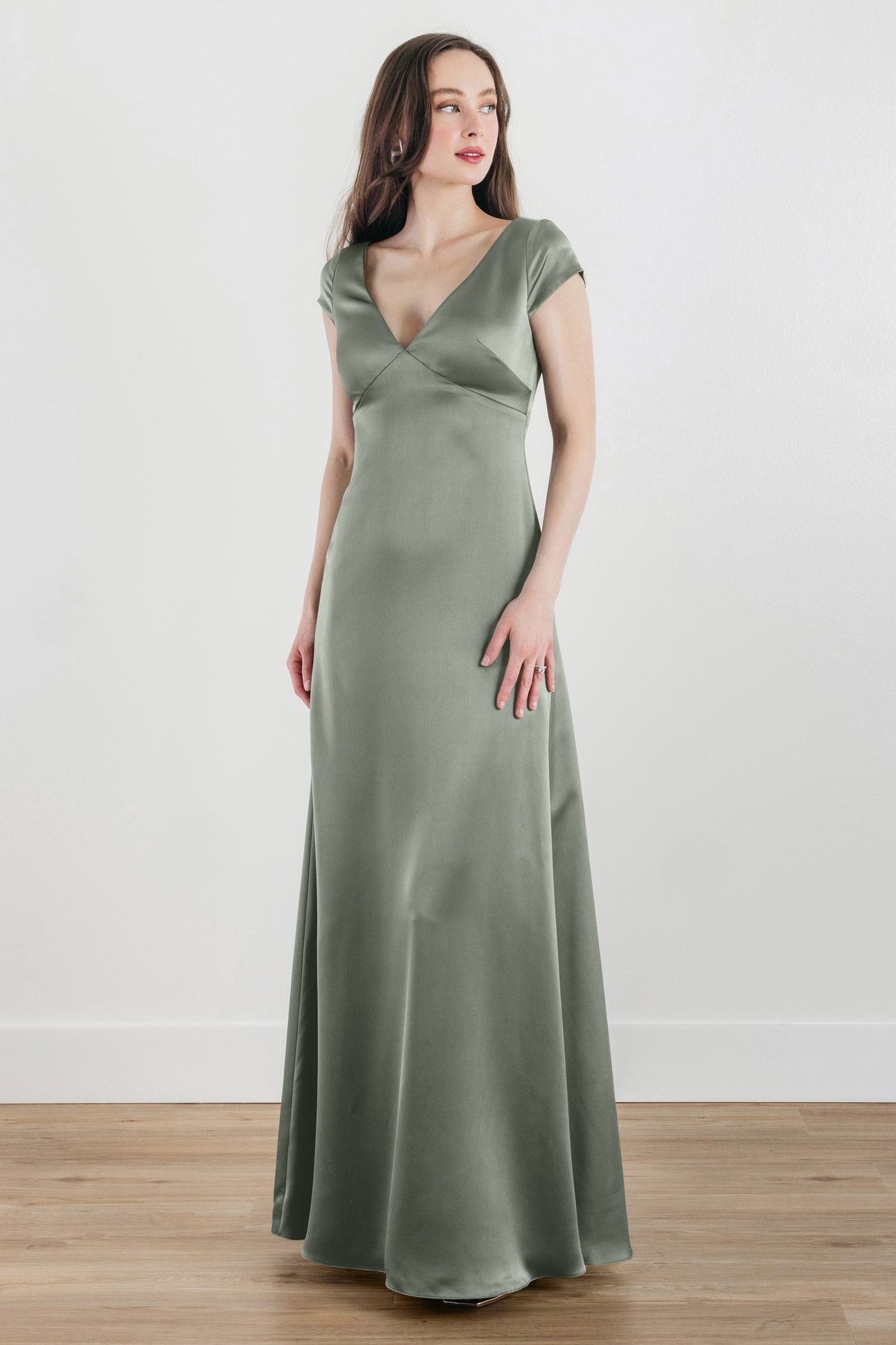 A woman is wearing a green satin dress with short sleeves.