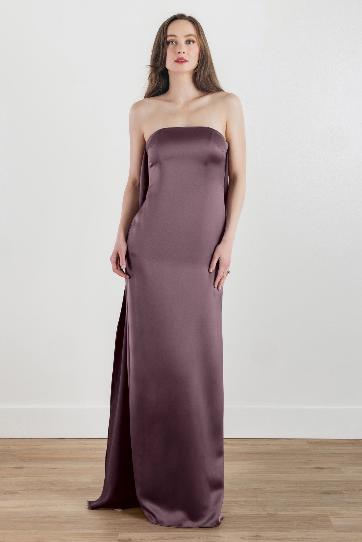A woman is wearing a strapless purple satin dress.