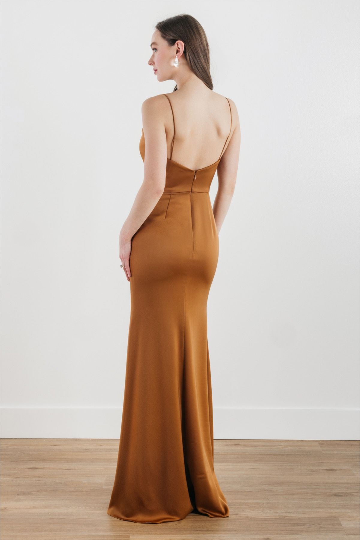 The back of a woman wearing a brown satin dress.