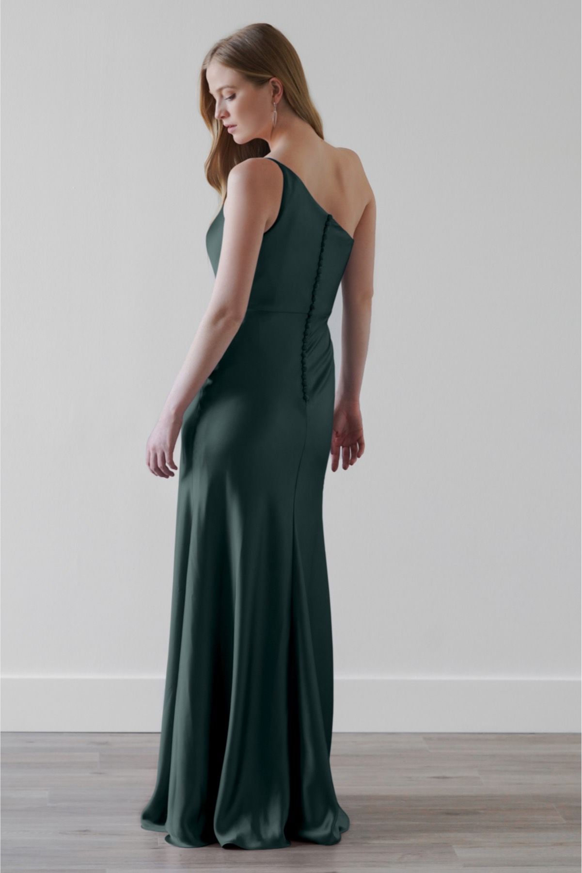The back of a woman wearing a green dress is shown.