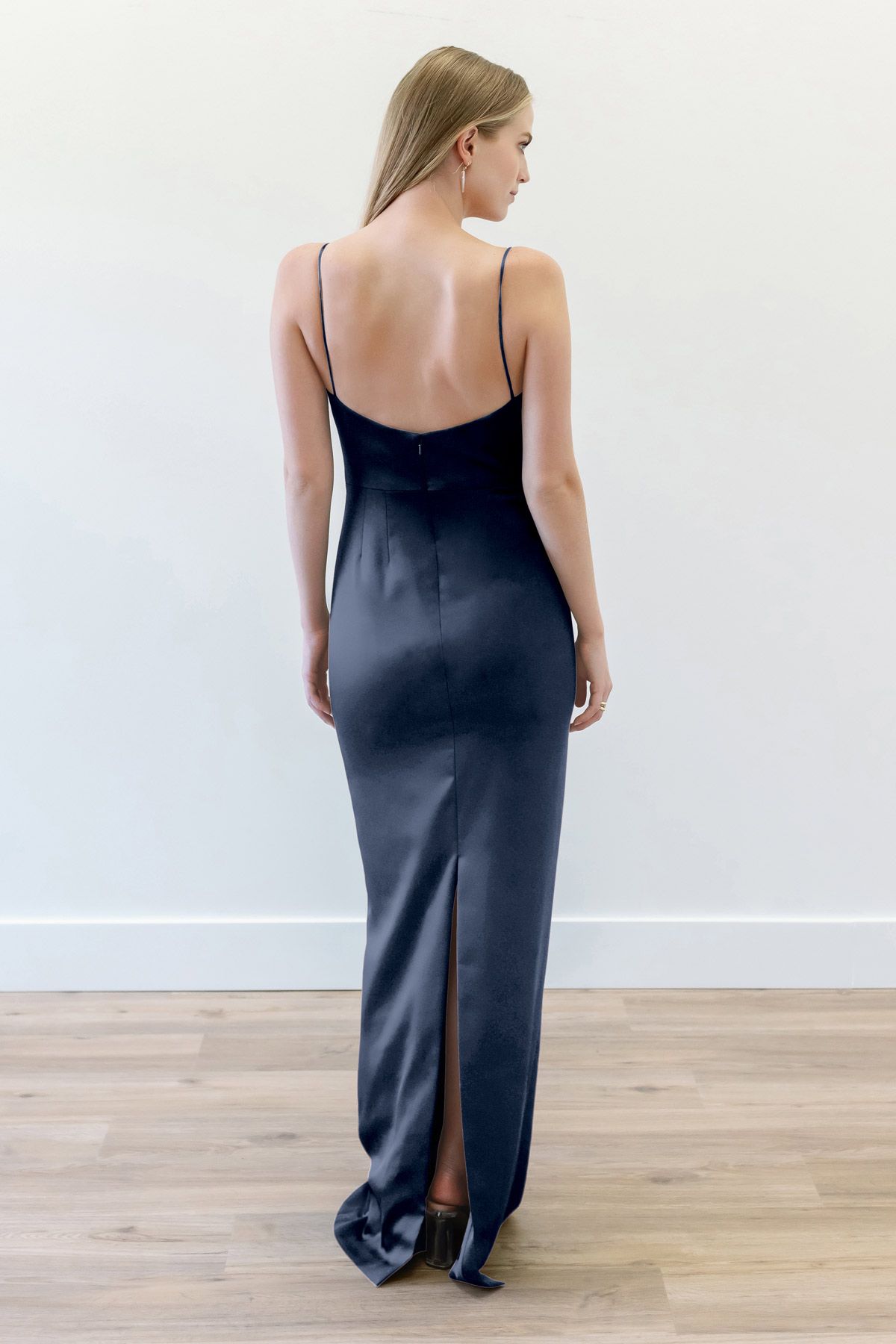 The back of a woman wearing a black dress is shown.