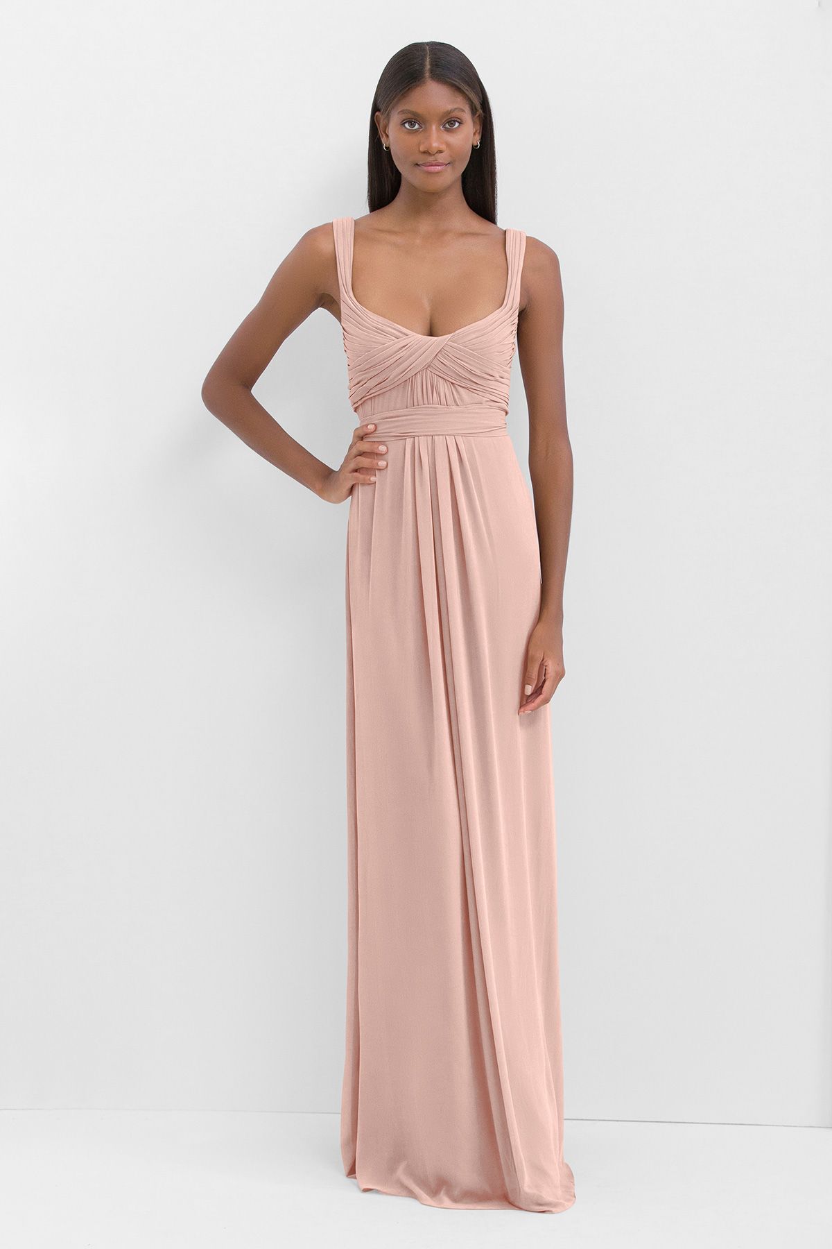 A woman is wearing a long pink dress with a plunging neckline.