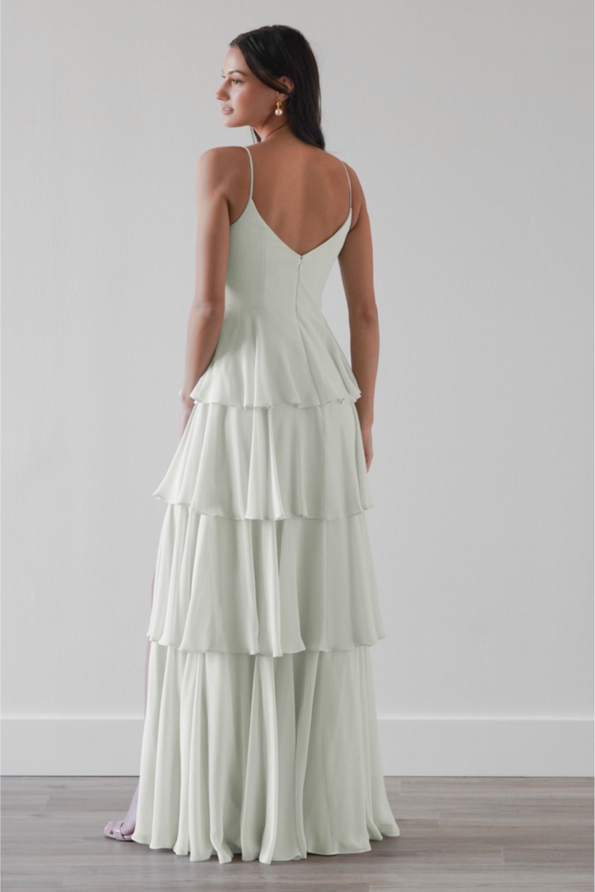 The back of a woman wearing a white tiered dress.