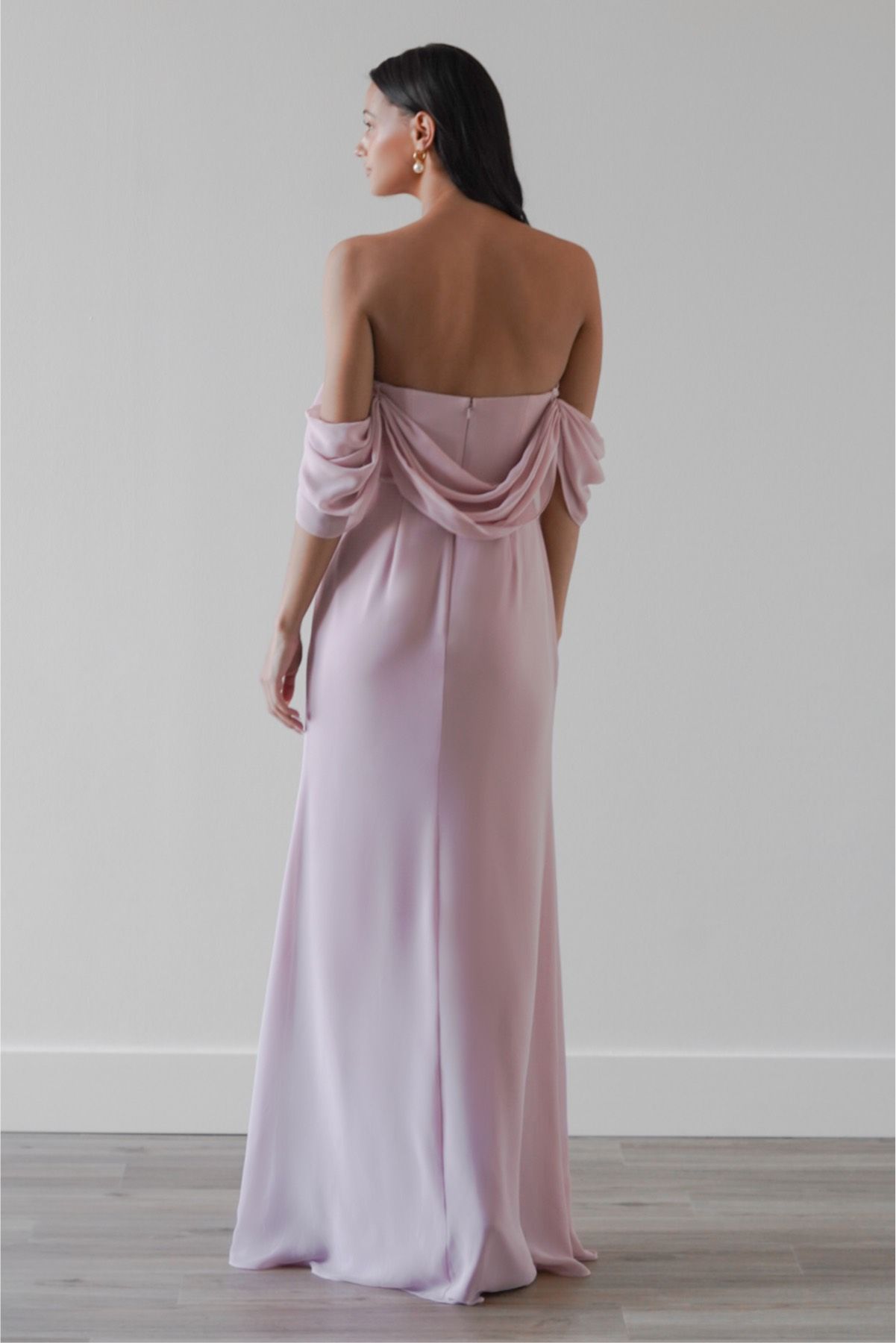 The back of a woman wearing a pink off the shoulder dress.