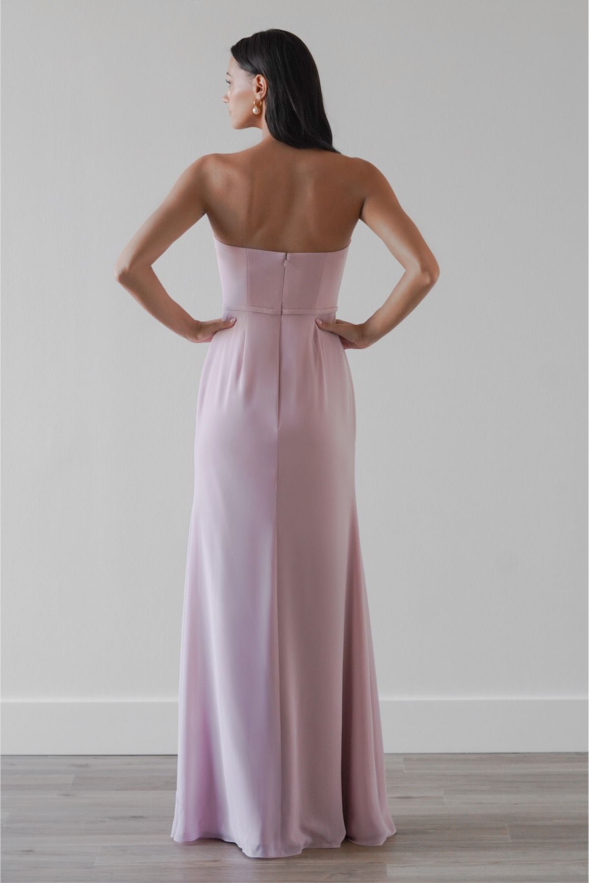 The back of a woman wearing a pink strapless dress.