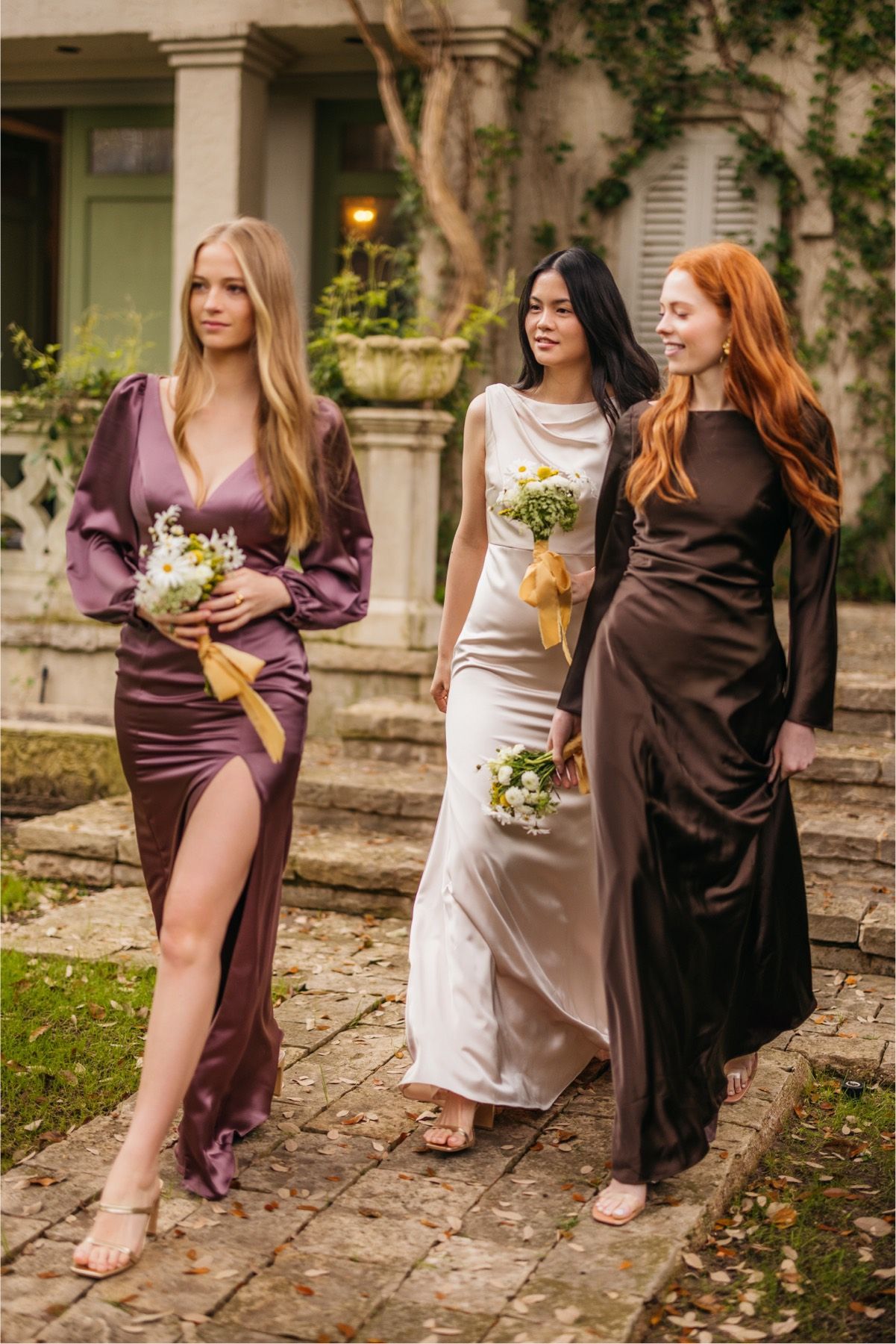 A group of women are walking down a sidewalk holding bouquets of flowers.