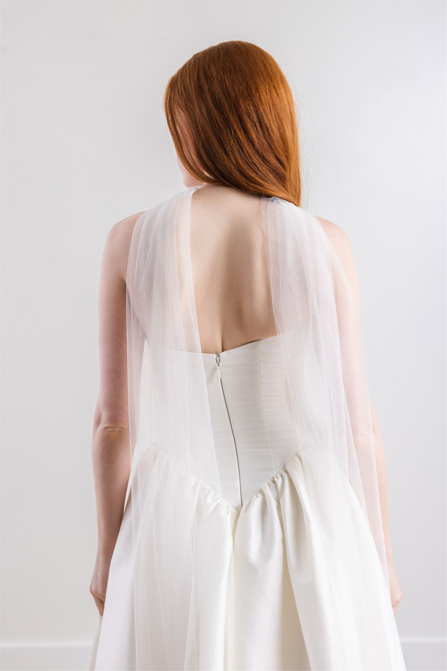 The back of a woman wearing a white wedding dress.