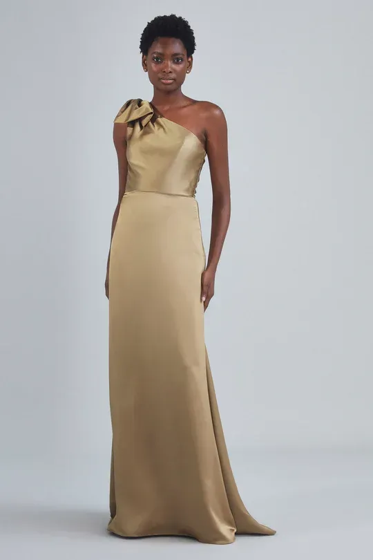 A woman is wearing a gold one shoulder dress