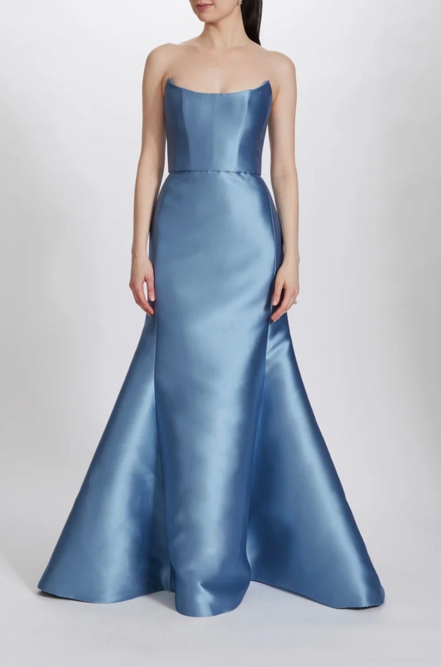 A woman is wearing a blue strapless satin gown