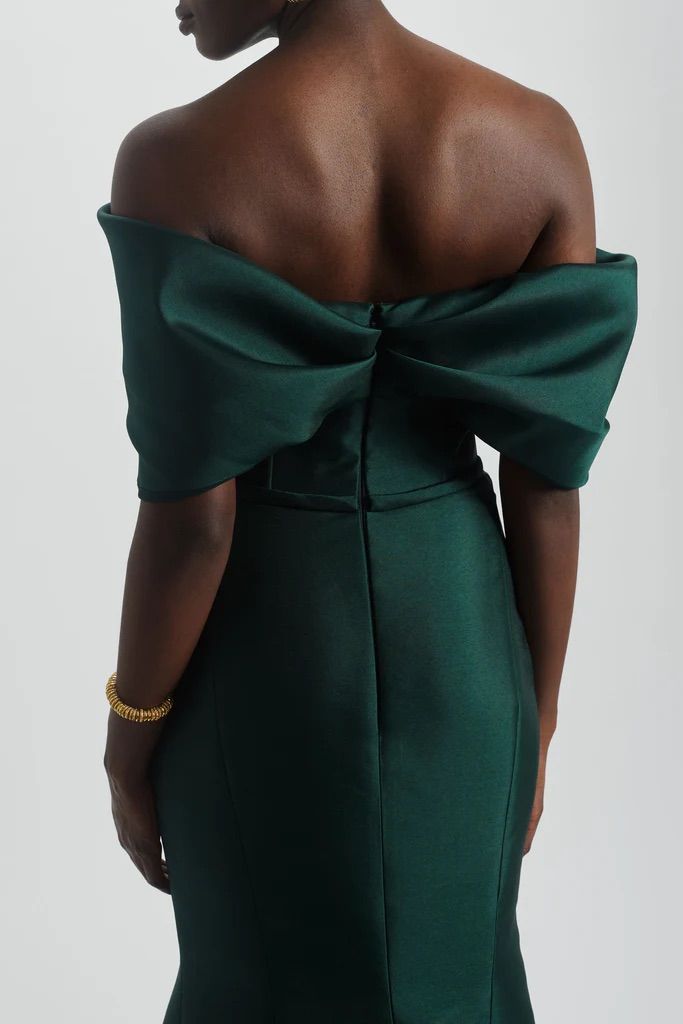 The back of a woman wearing a green dress with a bow