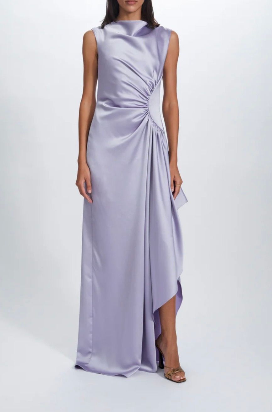 A woman in a purple dress is standing on a white background.