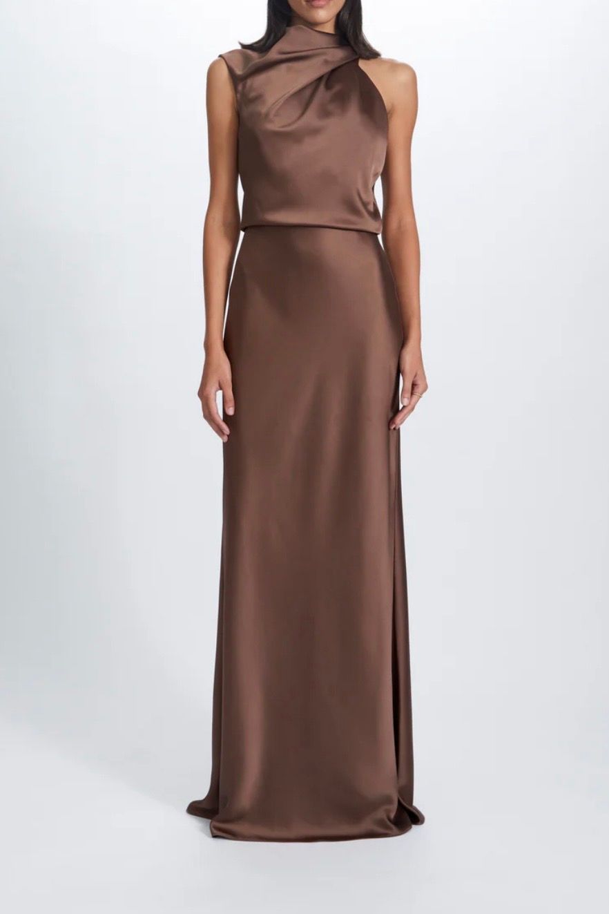 A woman is wearing a long brown satin dress.