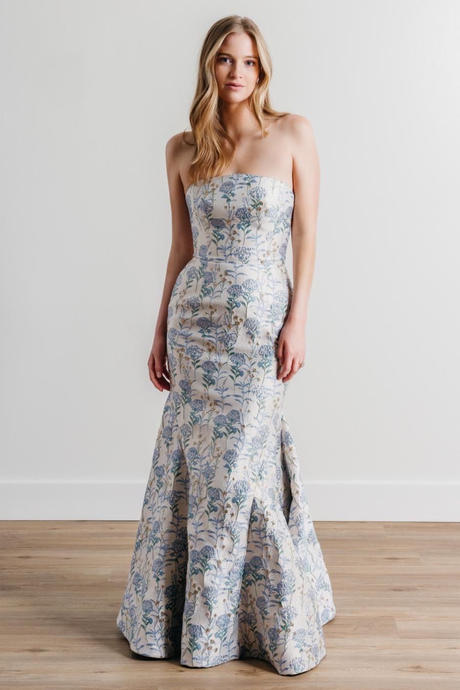 A woman is wearing a strapless blue and white floral dress.