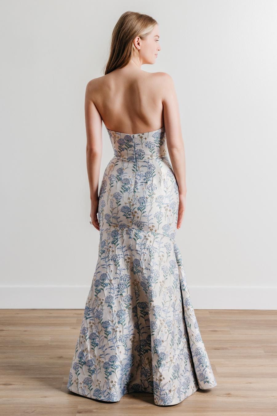 The back of a woman wearing a strapless dress is shown.