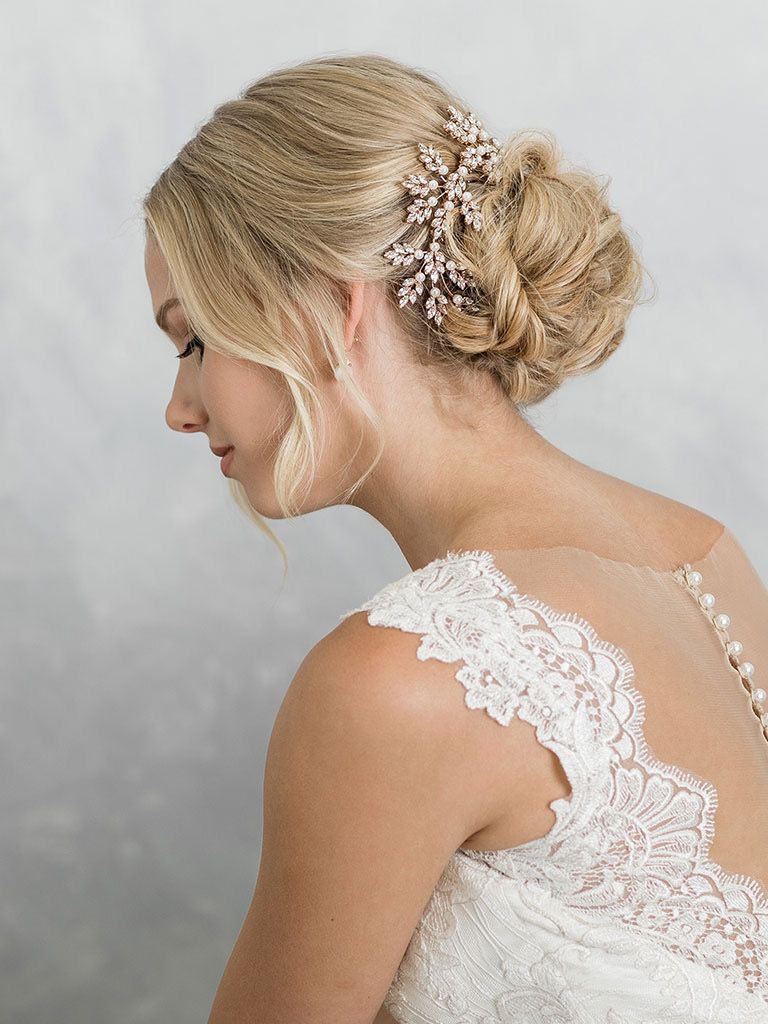 A woman in a wedding dress is wearing a hair clip in her hair.