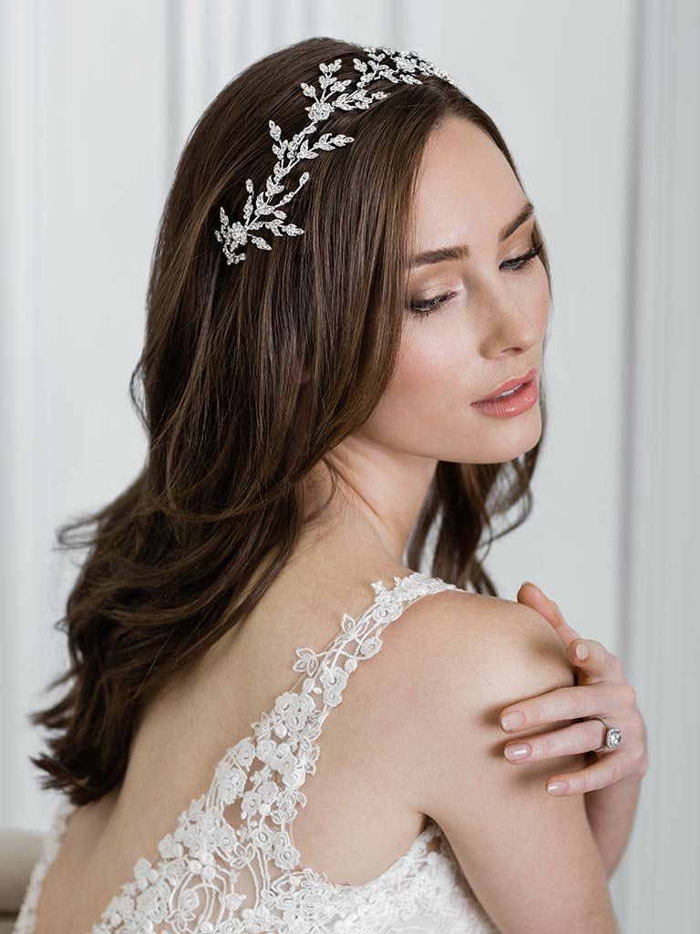 A woman in a wedding dress is wearing a headband in her hair.