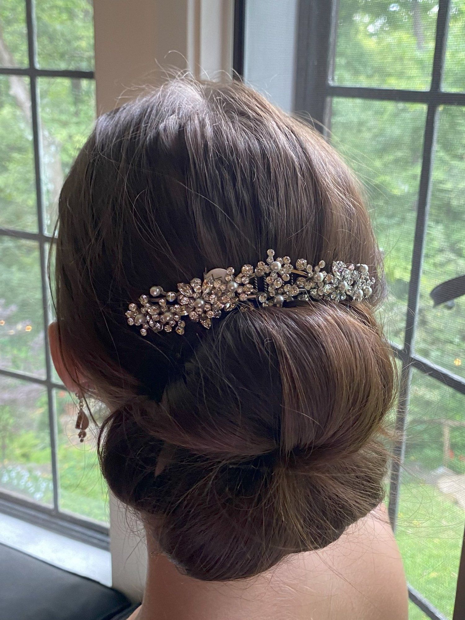 A woman is wearing a bun and a comb in her hair.