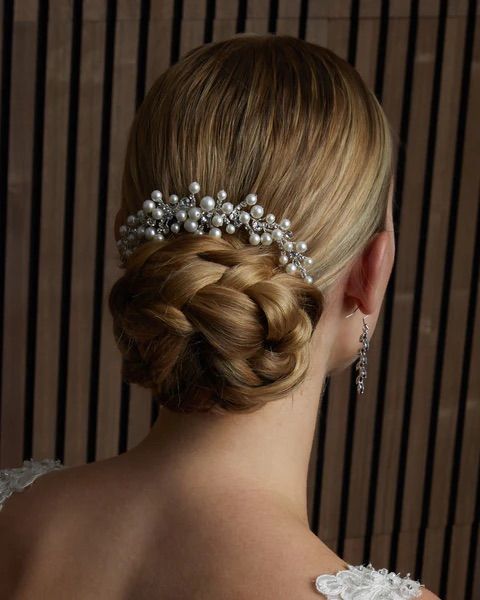 A woman wearing a bun with pearls in her hair