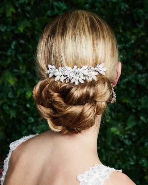 A woman in a white dress is wearing a comb in her hair.