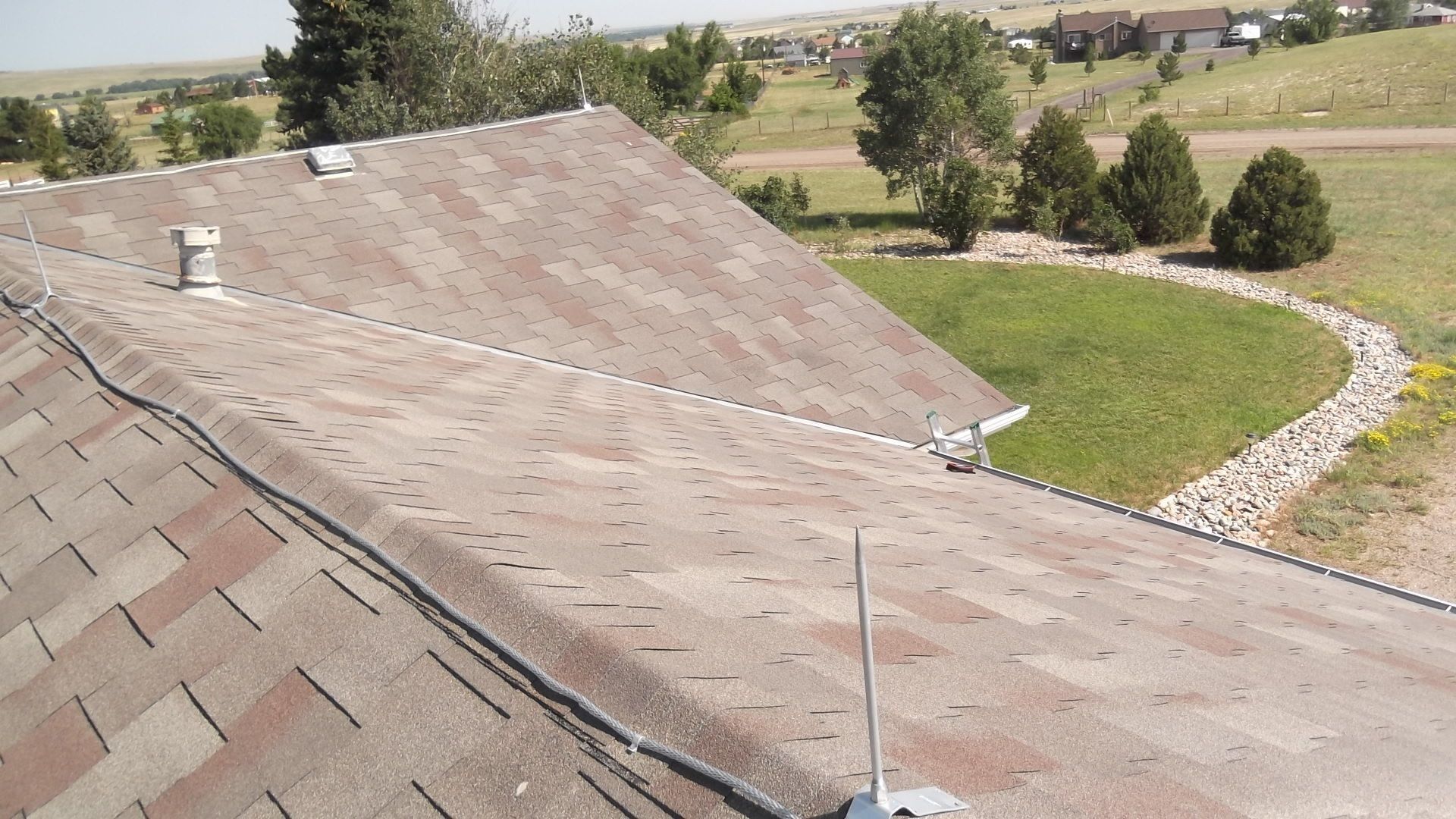 The roof of a house has a lightning rod on it