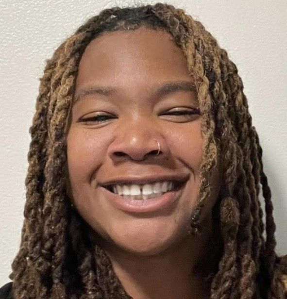 Skylar Jackson with dreadlocks is smiling for the camera .
