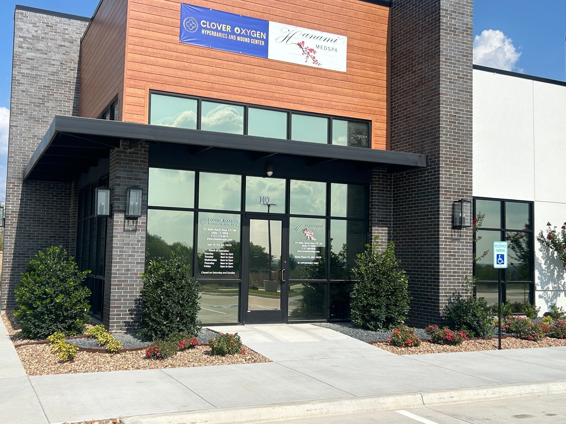 Exterior of a modern office building with a dark entryway, glass windows, and a wheelchair-accessible entrance.