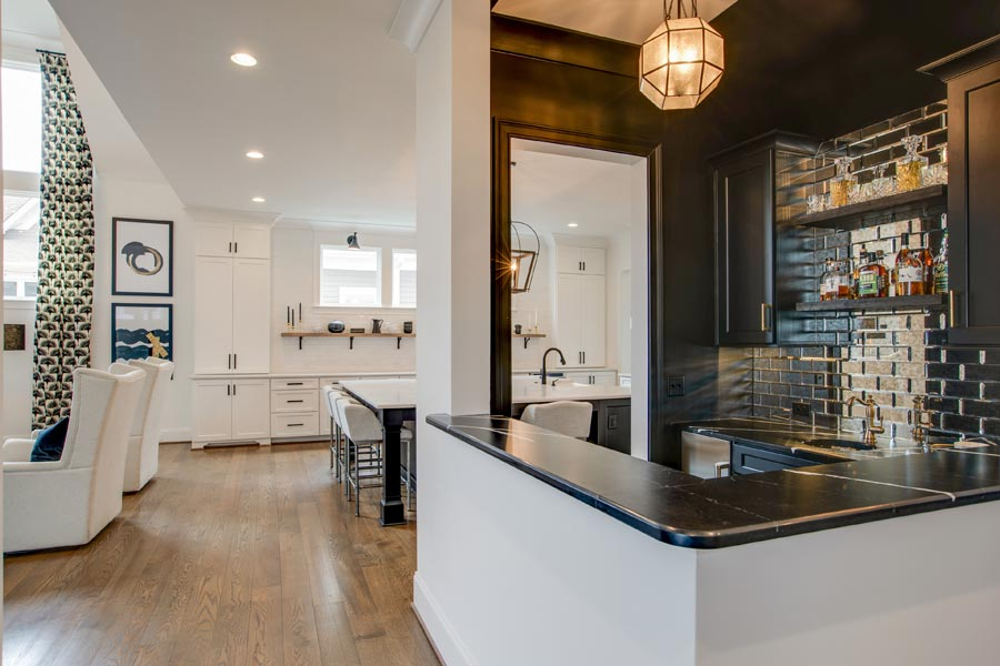 A kitchen with a bar and a living room in the background.