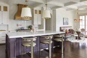 A kitchen with a purple island and white cabinets